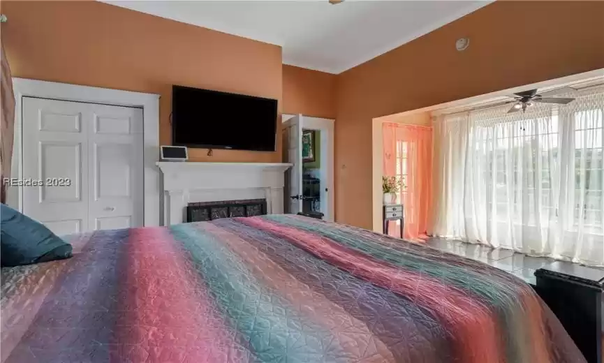 Bonus closet in the primary bedroom along with a cozy fireplace. Floor to ceiling windows providing views of the pool and abundant fruit trees.