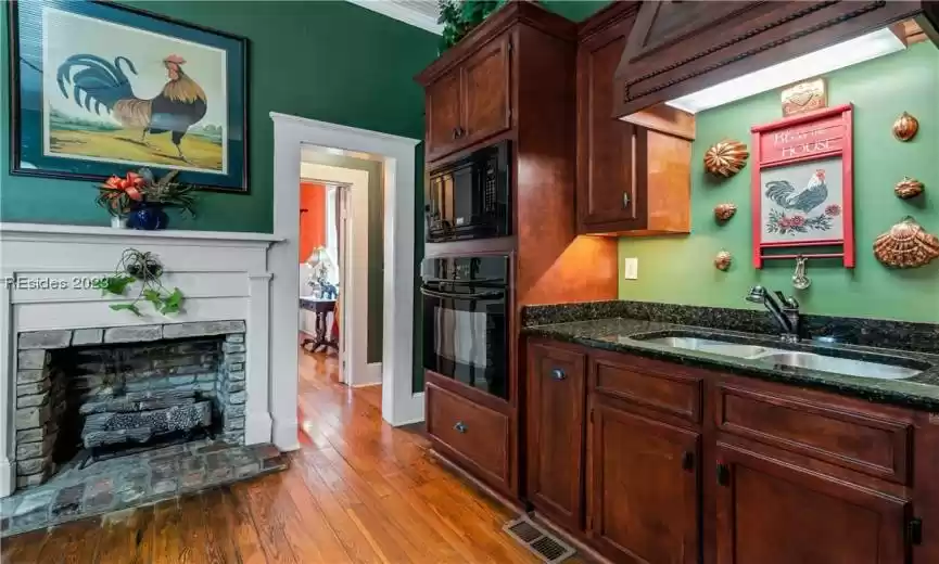 Now, let's talk about the heart of this kitchen - the fireplace. This charming addition creates a warm, welcoming atmosphere. Picture sipping your morning coffee or enjoying a cozy family dinner by the crackling fireplace.