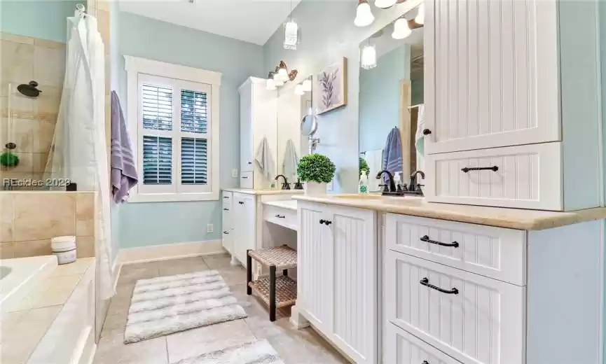 Primary bath has double sinks and makeup sitting areas.