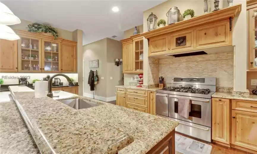 Kitchen with 6 burner SS gas stove enclave.