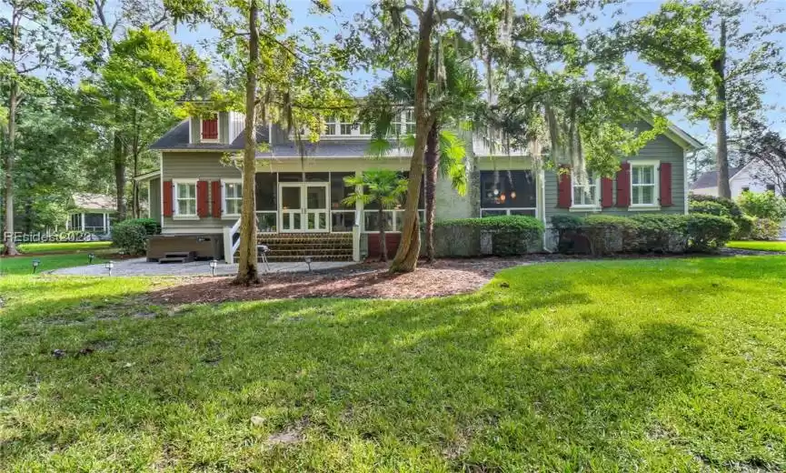 Back yard shows hot tub and back screened porch.