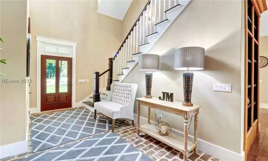 Front entry with brick flooring and beautiful stairwell.