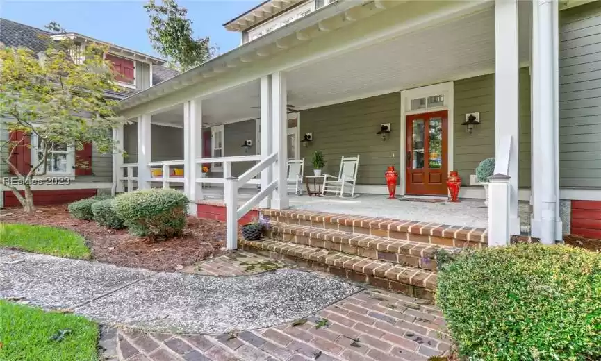 Front entrance with brick trimmed steps and transom window above door.