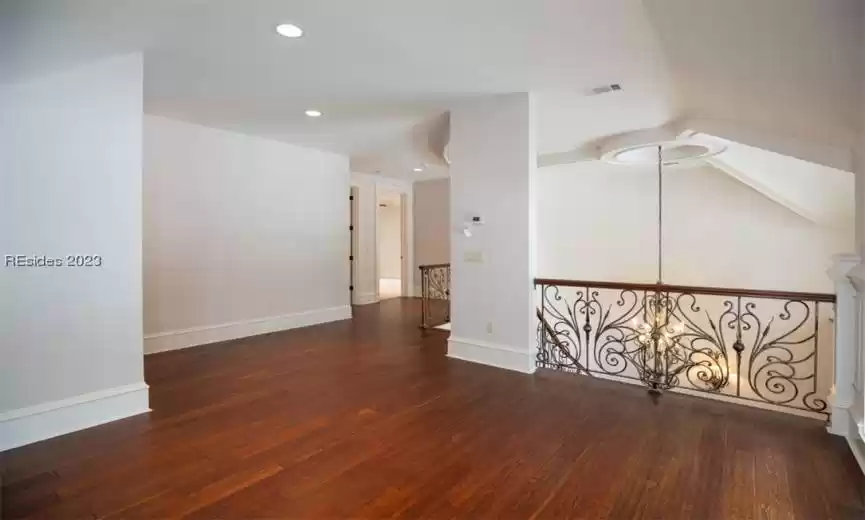 Upstairs landing room/loft with hidden storage built into the millwork and a half bath on the right side of the home.