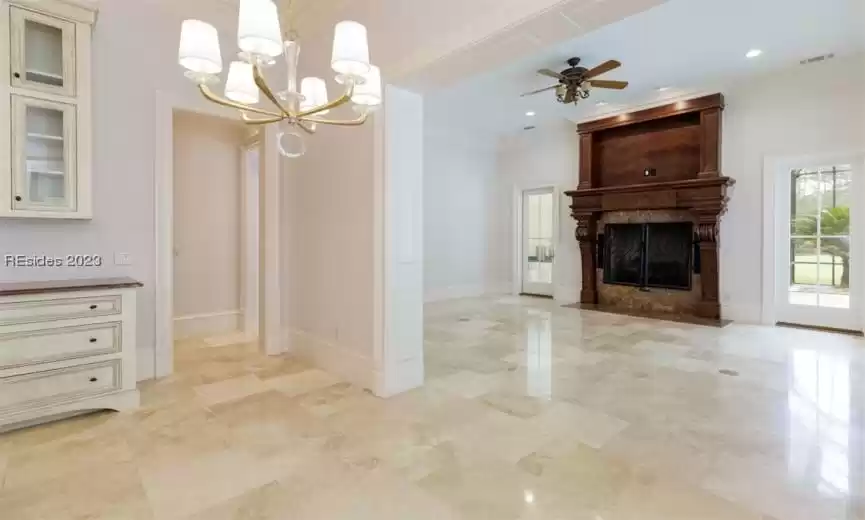 Eat-in kitchen area leading to second living area with custom fireplace.