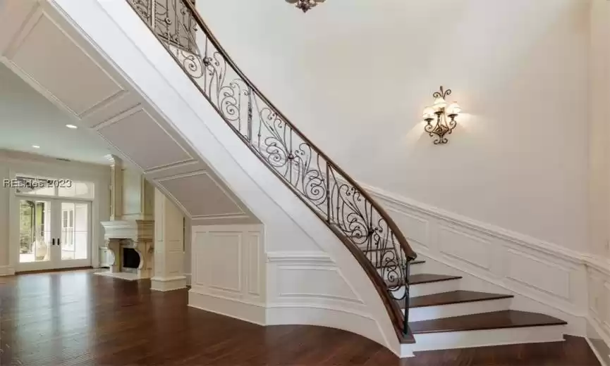 Custom ironwork staircase leading up to 2 ensuite bedrooms, a landing/loft space, and one half bath.