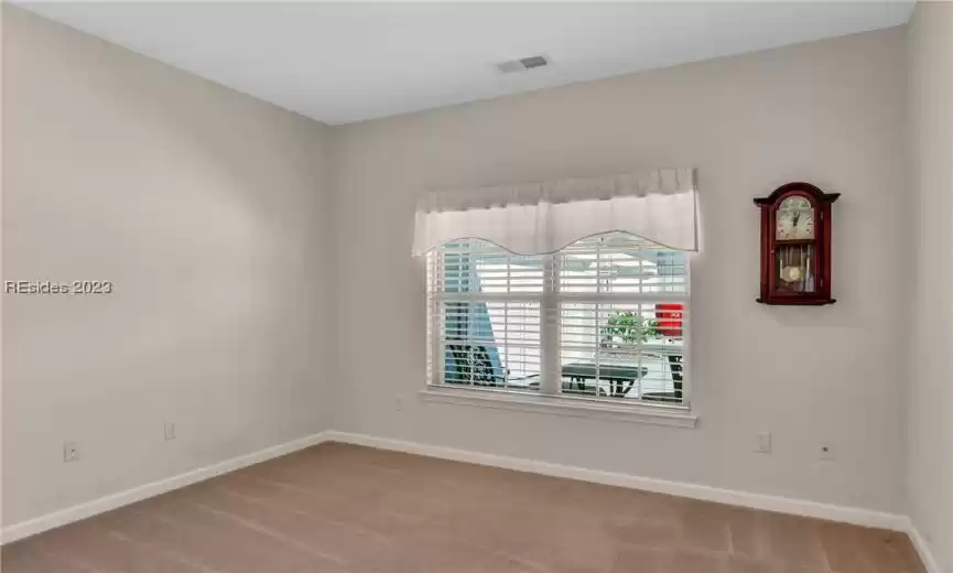 Guest bedroom number two with neutral carpeting.