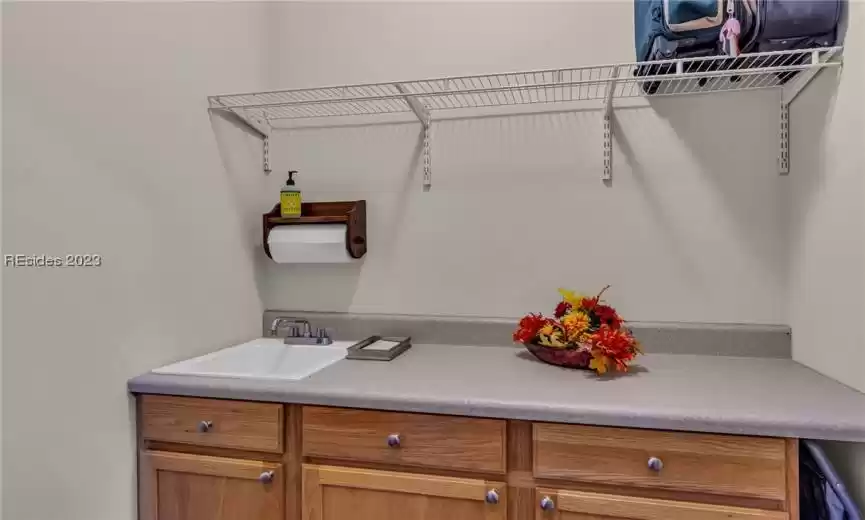 Bonus storage room adjacent to the laundry features sink, cabinets and shelving ... perfect for folding clothes, cleaning supplies pr extra storage.