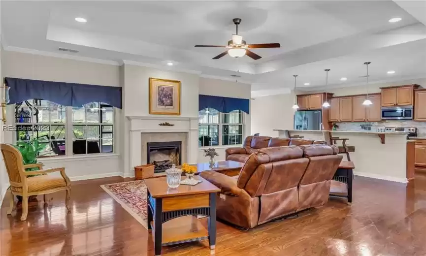 Here's the great room/living room with gleaming hardwood floors, fan/light overhead and an electric fireplace ... an appealing open floor plan.