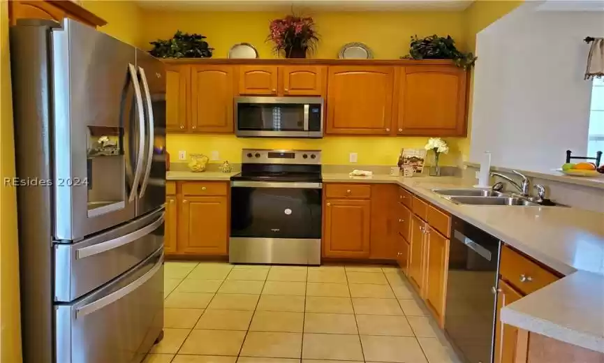 This kitchen has beautiful stainless appliances, Corian countertops and large breakfast bar.