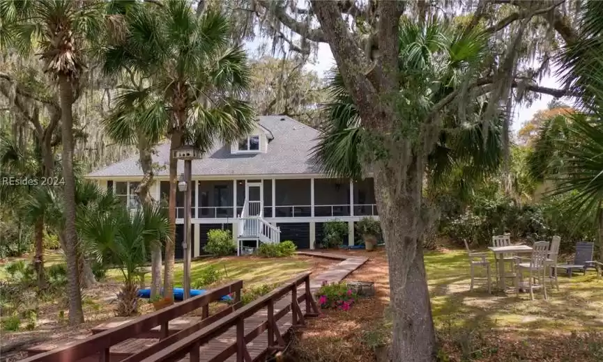 Rear view of property featuring a sunroom and a yard