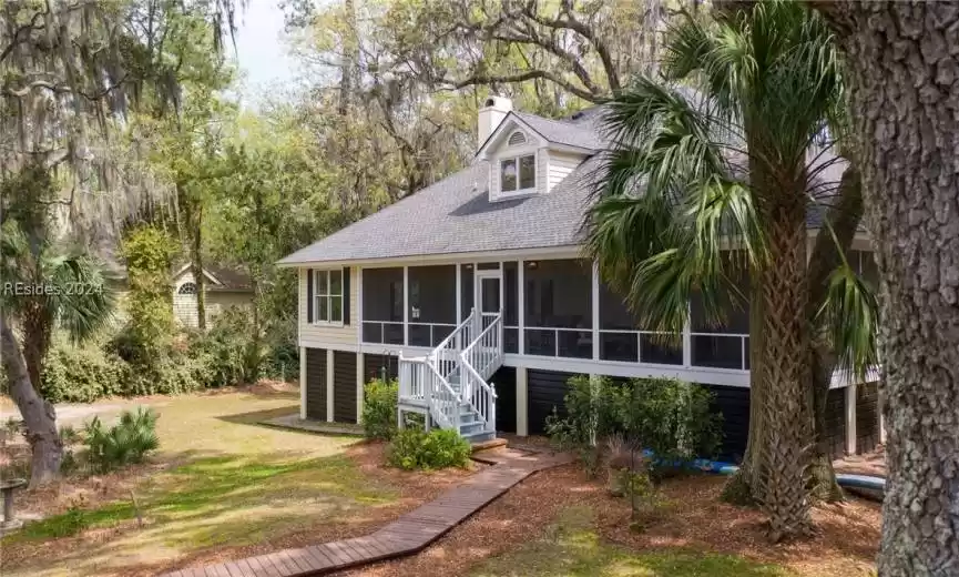 View of front facade featuring a front lawn and a sunroom