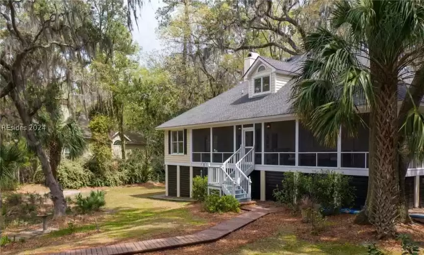 View of front of property with a sunroom and a front lawn