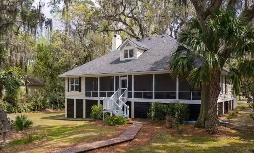 View of front of house with a front yard and a sunroom
