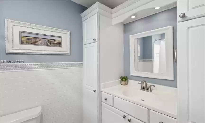 Bathroom with toilet, tile walls, and vanity