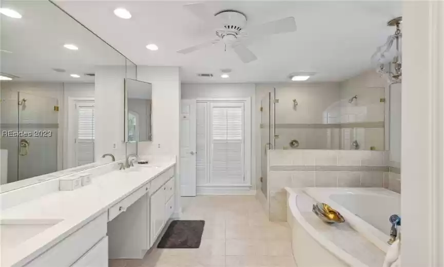 Bathroom with independent shower and bath, tile floors, ceiling fan, and dual vanity