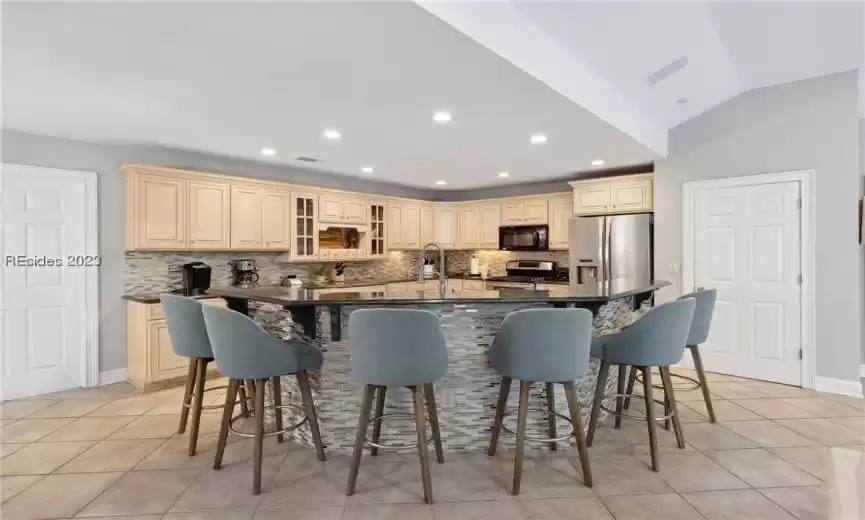 Kitchen featuring a kitchen breakfast bar, a spacious island, and appliances with stainless steel finishes