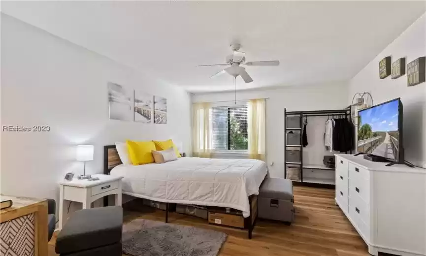 Bedroom featuring a textured ceiling, ceiling fan, and light hardwood / wood-style flooring