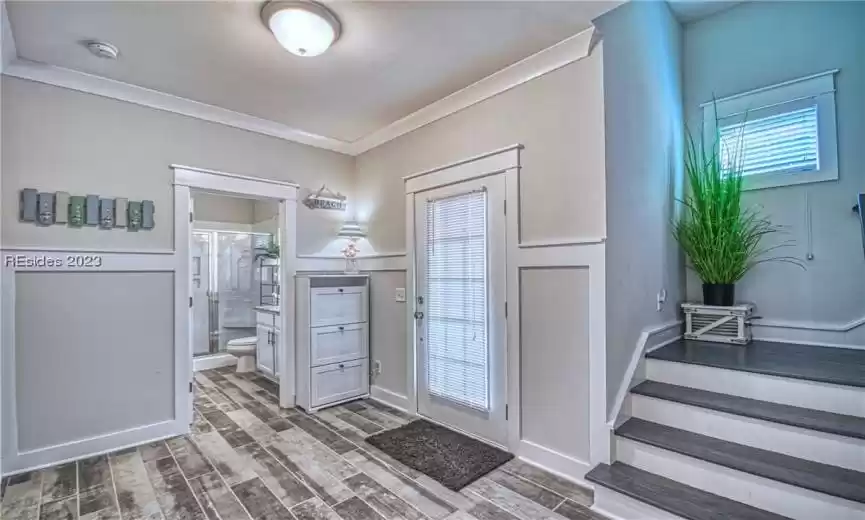 Foyer with ornamental molding and a healthy amount of sunlight