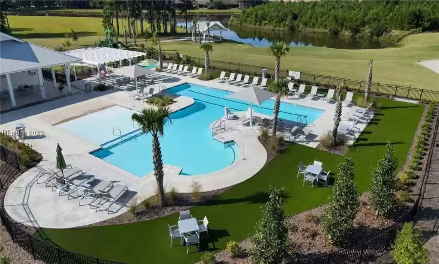 View of pool with a water view, a patio, and a yard