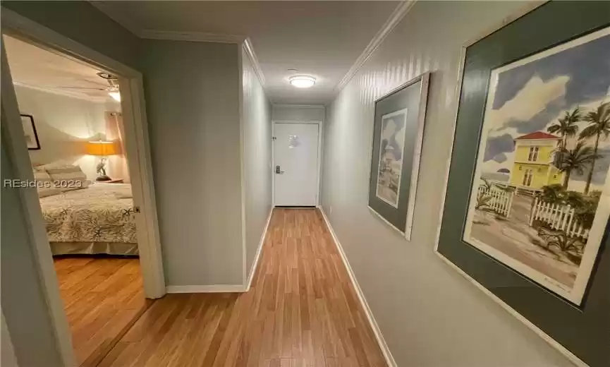 Hallway featuring ornamental molding and light hardwood / wood-style floors