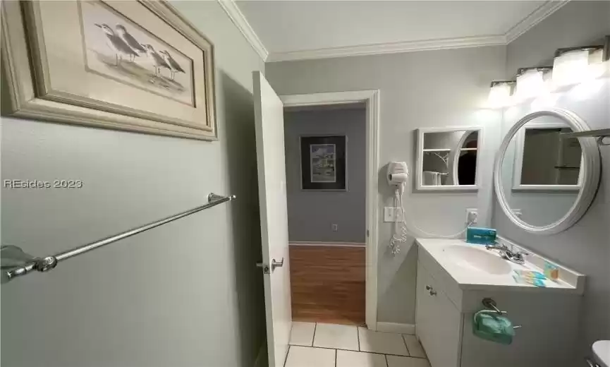 Bathroom with ornamental molding, tile flooring, toilet, and vanity