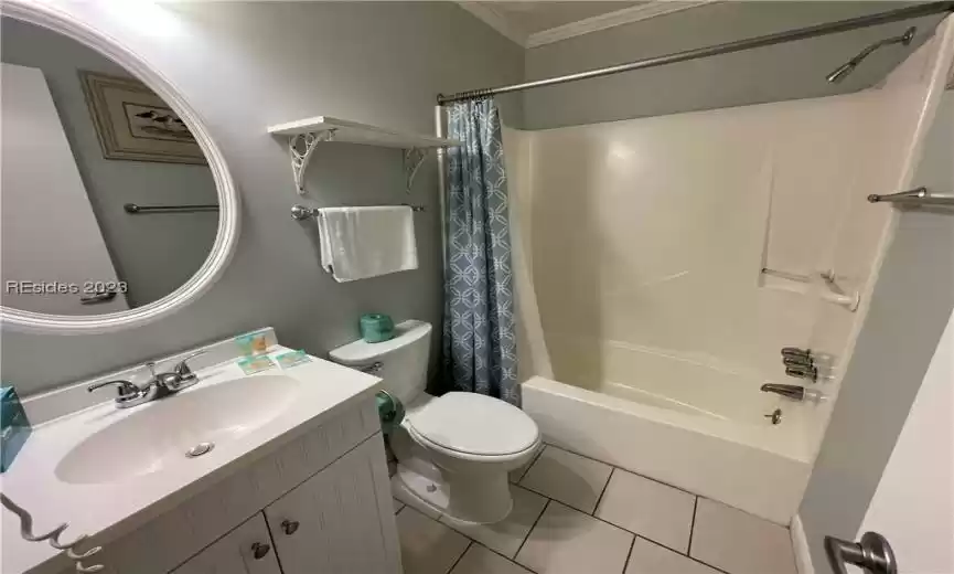 Full bathroom featuring crown molding, tile flooring, shower / tub combo, toilet, and oversized vanity