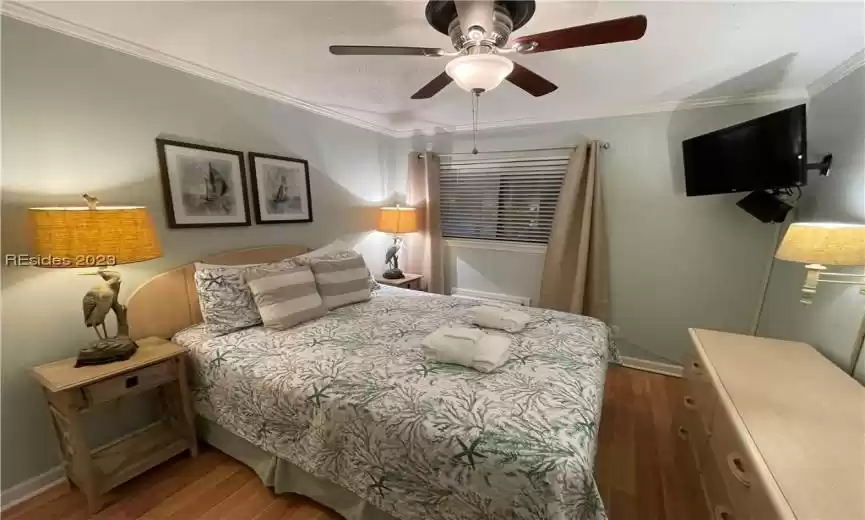Bedroom featuring Queen Bed, ceiling fan, flat screen tv and crown molding