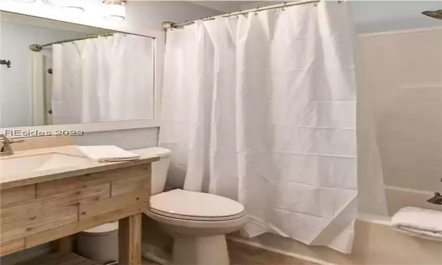 Full bathroom with toilet, shower / tub combo, and vanity