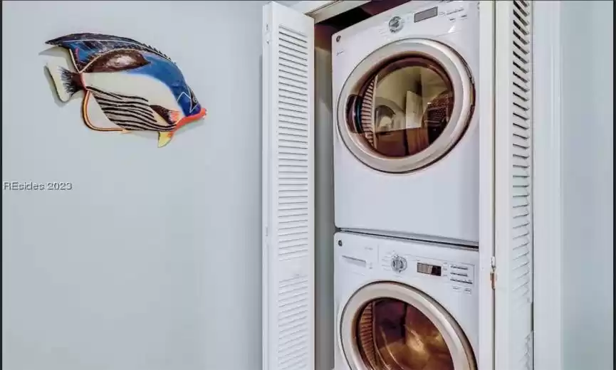 Laundry room featuring stacked full size washer and dryer