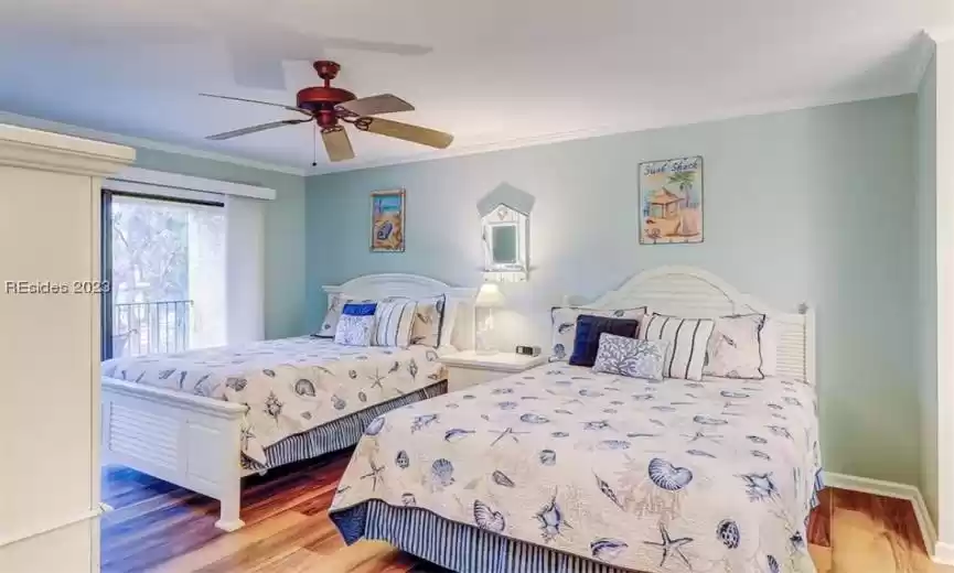 Bedroom with ornamental molding, light wood-type flooring, and ceiling fan