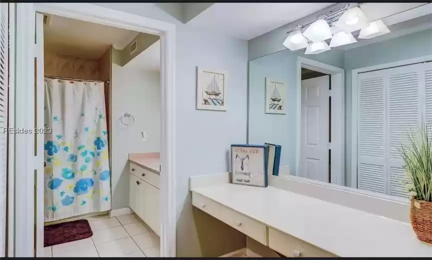 Bathroom featuring tile flooring, make up vanity and additional vanity with sink