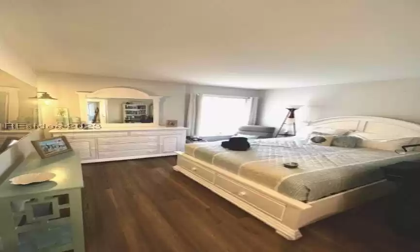 Bedroom featuring dark LVP wood-type flooring