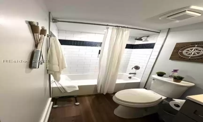 Full bathroom with toilet, shower / tub combo, vanity, and LVP wood-type flooring