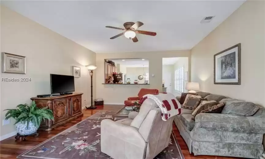 Living room featuring dark hardwood / wood-style flooring and ceiling fan