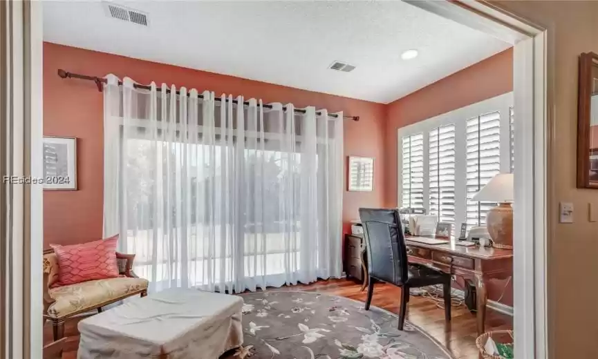 Home office with wood-type flooring and a textured ceiling