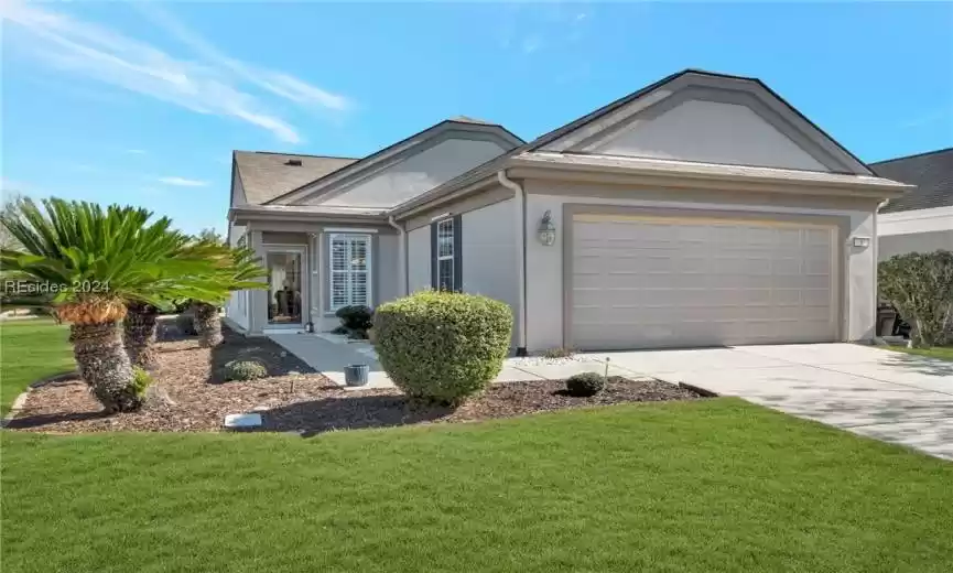 Ranch-style home with a front yard and a garage