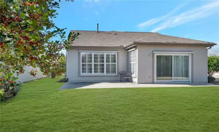 Back of property featuring a lawn and a patio area