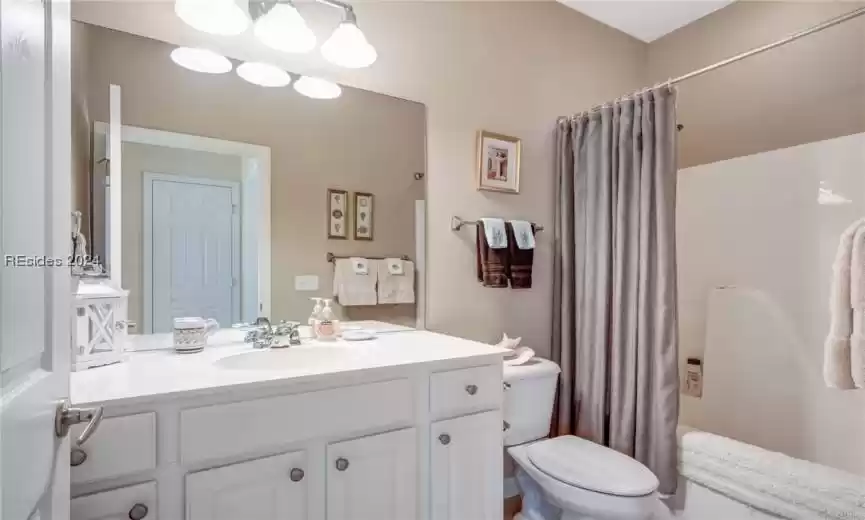 Bathroom featuring toilet and vanity with extensive cabinet space
