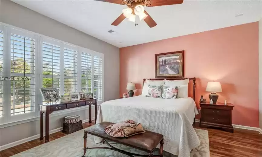 Bedroom with dark hardwood / wood-style floors, ceiling fan, and a textured ceiling