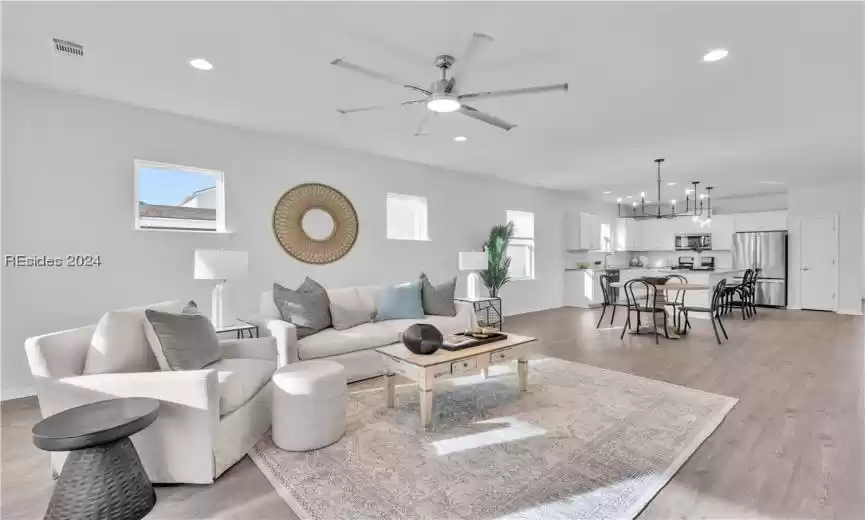 Spacious Living room featuring Luxury LVP in light wood-style and ceiling fan