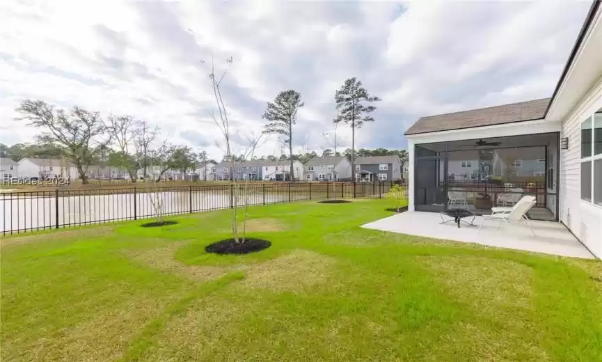 View of yard with Screened-in porch, Patio, ceiling fan and Lagoon View