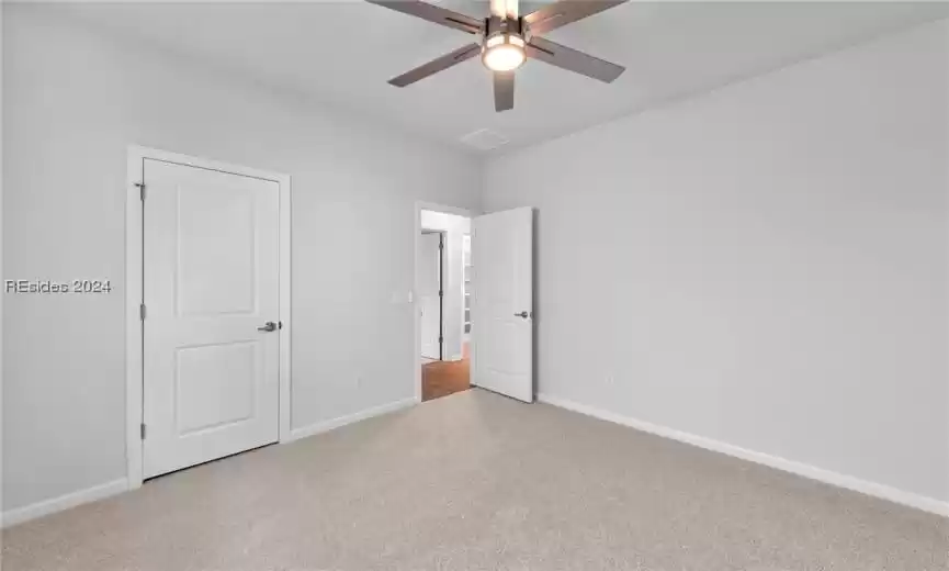 Spare room with light carpet and ceiling fan