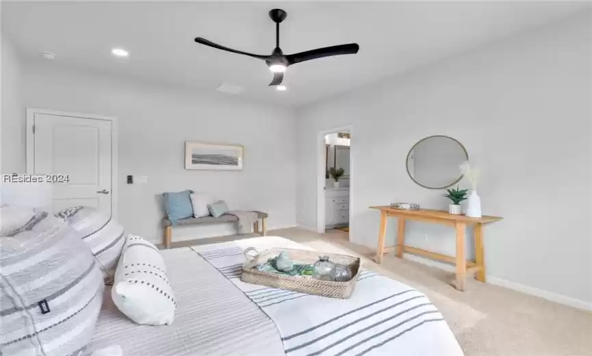 Primary bedroom featuring ensuite bathroom and ceiling fan