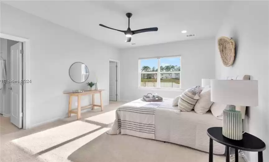 Primary bedroom featuring neutral carpet and ceiling fan