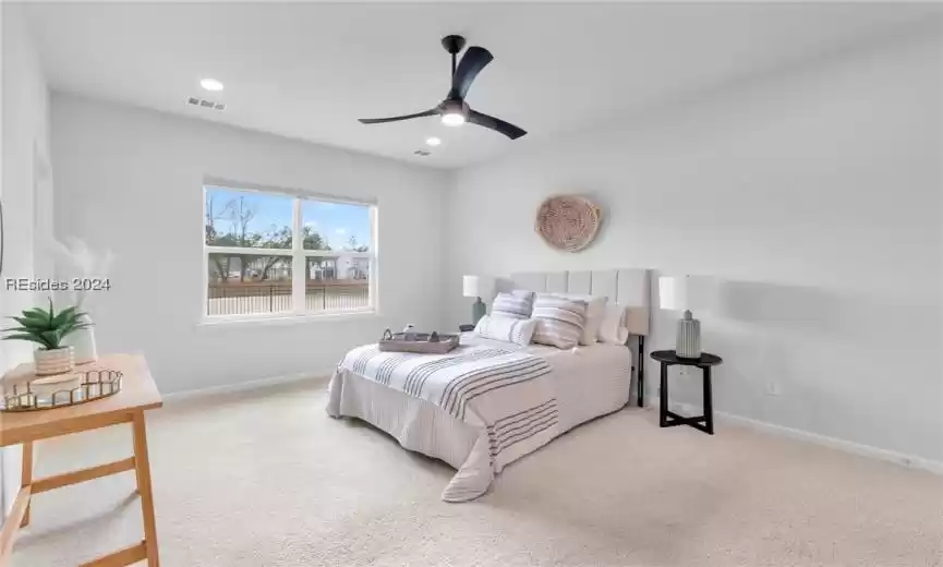 Bedroom featuring ceiling fan and neutral carpet