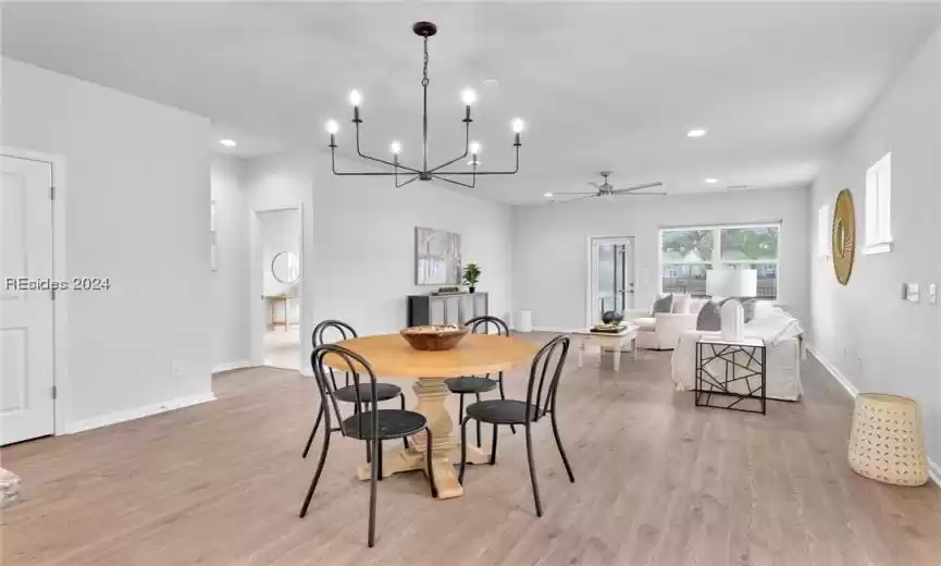 Dining space open to Living Area featuring light hardwood / wood-style flooring and ceiling fan with notable chandelier