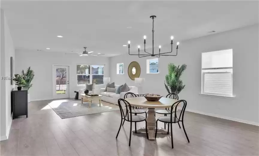 Dining room featuring light hardwood style Luxury LVP/ wood-style floors and beautiful chandelier