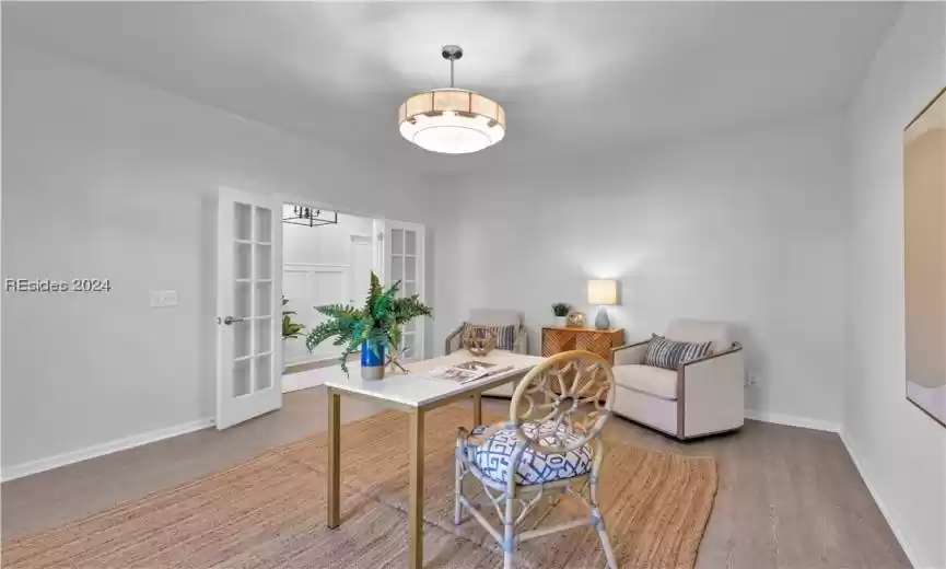 Home office/flex room featuring hardwood / wood-style flooring and french doors