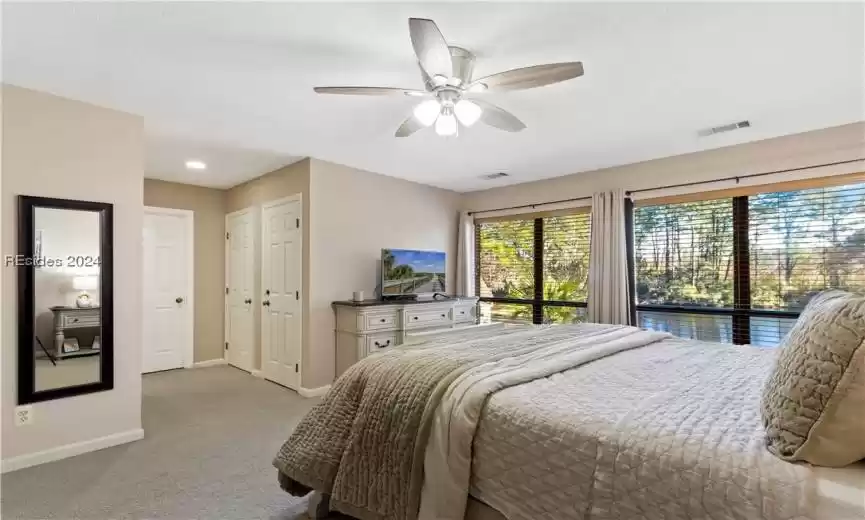 Carpeted bedroom featuring access to exterior, ceiling fan, a textured ceiling, and a closet